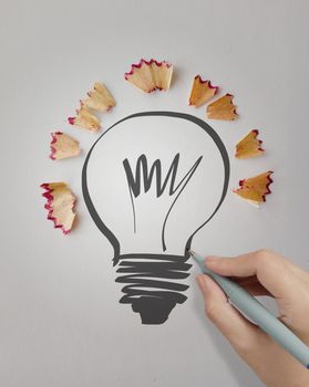 hand drawn light bulb with pencil saw dust on paper background as creative concept