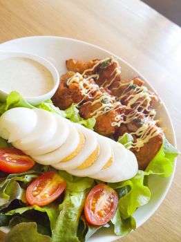 Fresh salad with chicken breast,lettuce and tomatoes on wooden table
