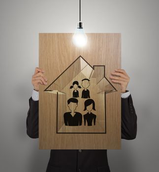 businessman show hand draw family and house on wooden poster as insurance concept