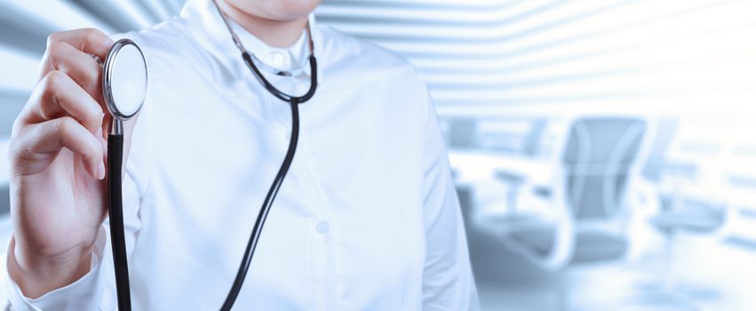 Doctor with a stethoscope in the hands and office background 