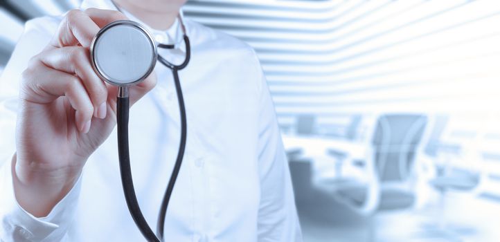 Doctor with a stethoscope in the hands and office background 