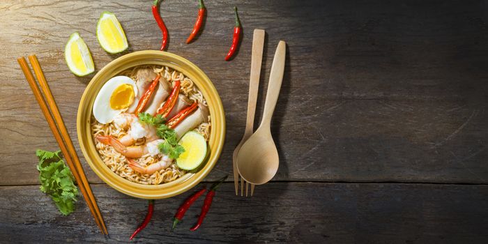 Thai food style noodle, tom yum kung on wood background and space for text