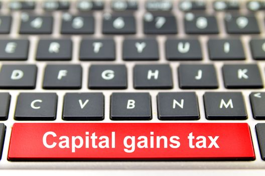 Capital gains tax word on computer keyboard, 3D rendering