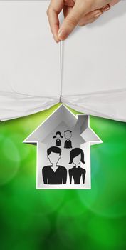 hand open crumpled paper to show hand draw family and house icon on green nature background as insurance concept 