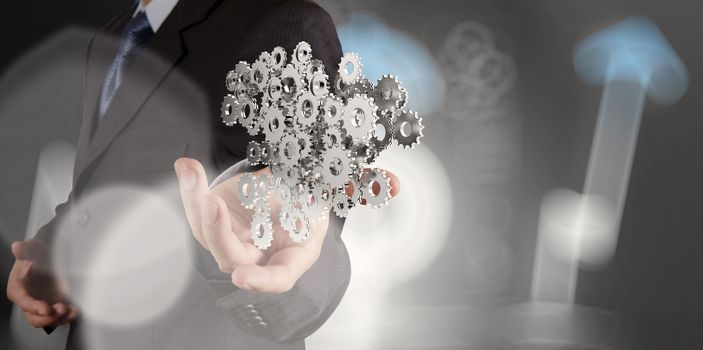 businessman hand showing gears cogs to success concept