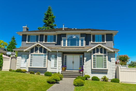 Big family house in suburbs of Vancouver on blue sky background