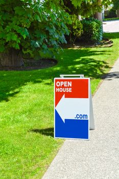 Real estate sign 'Open House' on a pavement site.