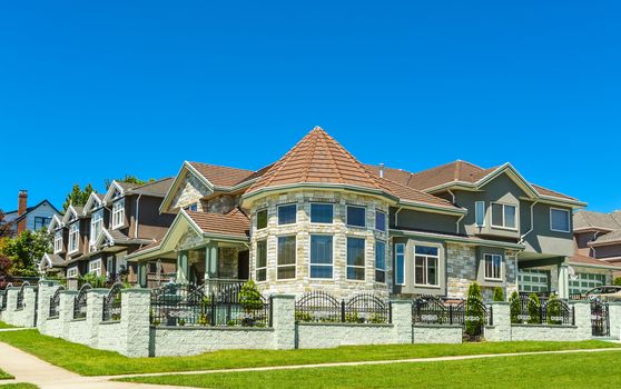 High end custom built luxury house with rotunda in a residential neighborhood on blue sky background