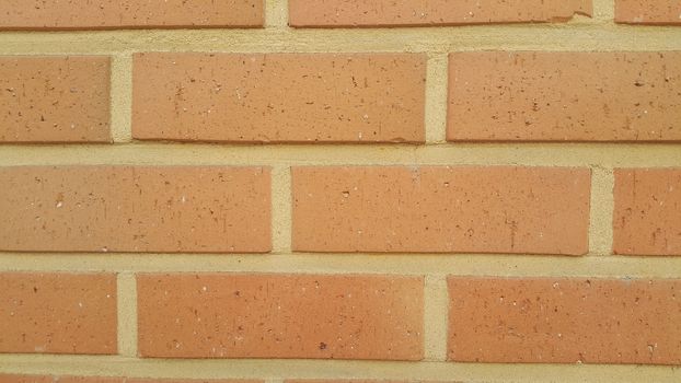 Closeup texture of red brick wall. A background of a weathered old exterior brick wall in the sunshine.