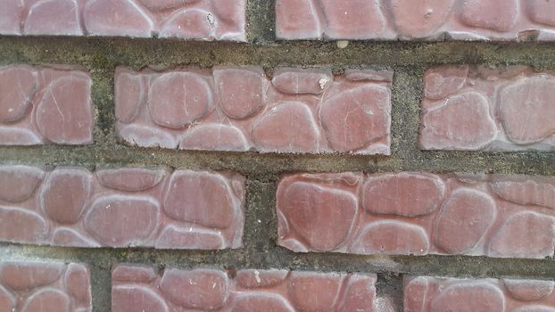 Closeup texture of red brick wall. A background of a weathered old exterior brick wall in the sunshine.