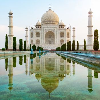 Taj Mahal front view reflected on the reflection pool, an ivory-white marble mausoleum on the south bank of the Yamuna river in Agra, Uttar Pradesh, India. One of the seven wonders of the world.