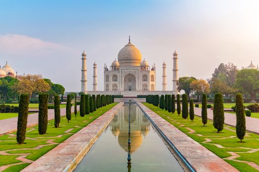 Taj Mahal front view reflected on the reflection pool, an ivory-white marble mausoleum on the south bank of the Yamuna river in Agra, Uttar Pradesh, India. One of the seven wonders of the world.