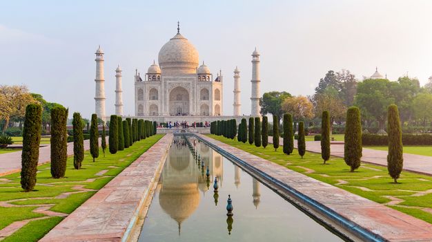 Taj Mahal front view reflected on the reflection pool, an ivory-white marble mausoleum on the south bank of the Yamuna river in Agra, Uttar Pradesh, India. One of the seven wonders of the world.