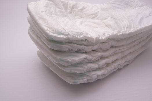 A close-up view of a stack of five disposable baby diapers.