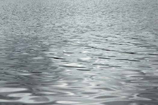 Silver reflections on the waters of a lake. Full frame texture detail.