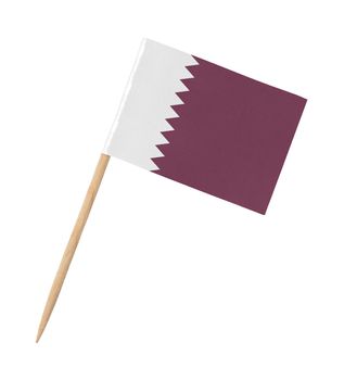 Small paper flag of Qatar on wooden stick, isolated on white