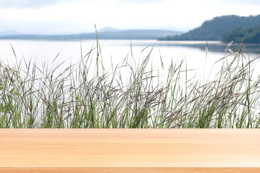 wood plank on grass nature and surface water at river landscape mountain range, empty wood table floors on sierra cordillera, wood table board empty front grass and sky mornings sun shine