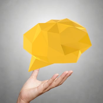 hand showing low poly geometric speech bubble on white background