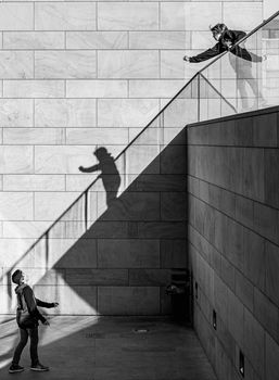 Black and white image of 2 young boys on different levels playing with a bouncy rubber ball