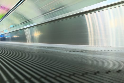 Motion blurred shot of a moving walkway at an airport. Close up.