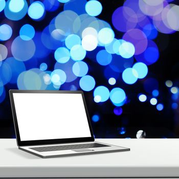 Laptop with blank screen on laminate table and blurred background