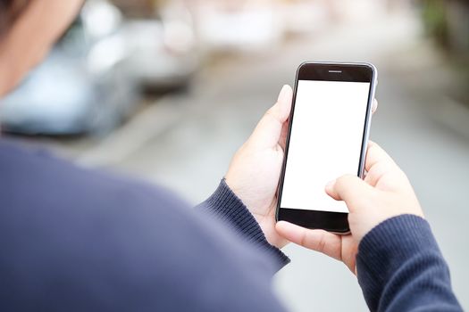 Cropped shot view of man hands holding smart phone with blank copy space screen for your text message or information content, female reading text message on cell telephone during in urban setting. 