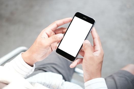 Cropped shot view of man hands holding smart phone with blank copy space screen for your text message or information content, female reading text message on cell telephone during in urban setting. 