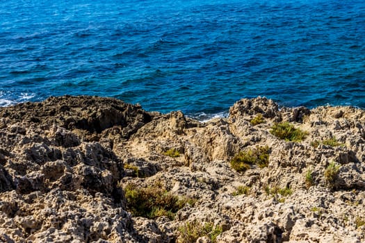 Mediterranean coast on a sunny day with rocks and blue waves.