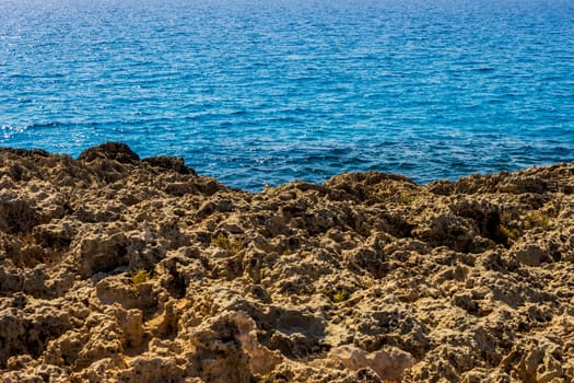 Mediterranean coast on a sunny day with rocks and blue waves.