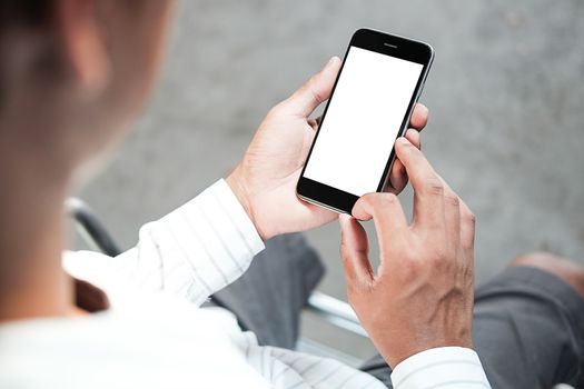 Cropped shot view of man hands holding smart phone with blank copy space screen for your text message or information content, female reading text message on cell telephone during in urban setting. 