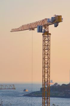 Construction crane by the sea in Istanbul, Turkey. Construction industry, high rise real estate investment concept.