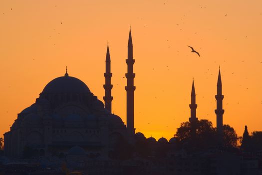 Hagia Sophia, the most important tourist attraction of Istanbul, Turkey, silhouetted against the ochre sunset sky.