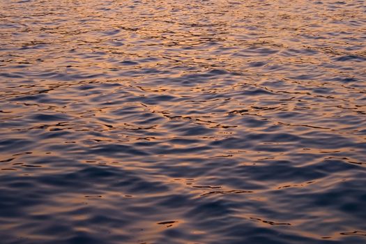 Dark waters reflecting the ochre colors of a sunset sky.