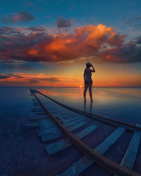 Woman at beauty sunset on salty lake