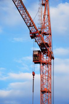 Industrial theme. Red construction crane against blue sky