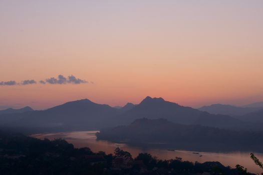 Twilight colors over hazy mountains by the Mekong river. View from Mount Phou Si, in Luang Prabang, Laos.