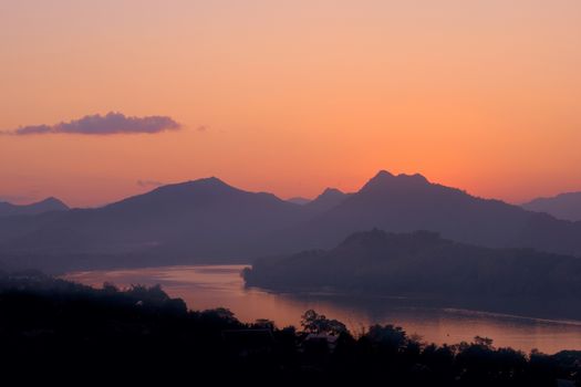 Twilight colors over hazy mountains by the Mekong river. View from Mount Phou Si, in Luang Prabang, Laos.