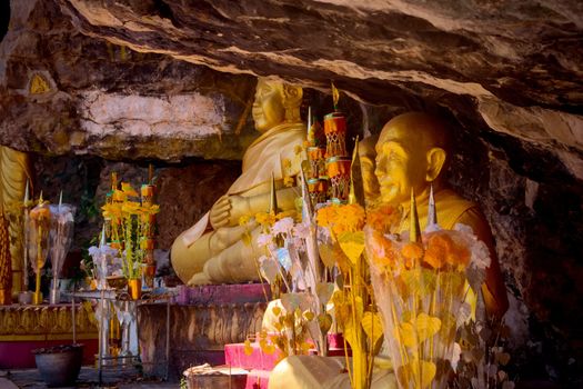 Golden statues of buddhist monks on a crevice of the rock at Mount Phou Si, in Luang Prabang, Laos.