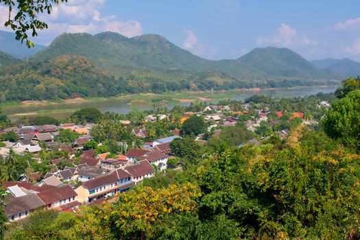 Elevated view of the town of Luang Prabang, Laos, from Mt. Phou Si, with the Mekong River on the background.