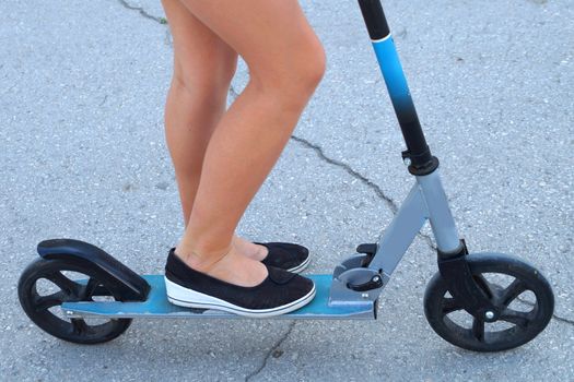 legs of a girl on a scooter, photo of the bottom.