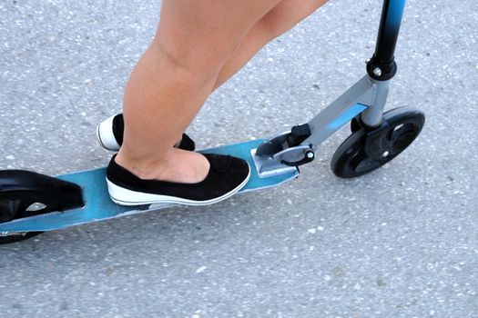 legs of a girl on a scooter, photo of the bottom.