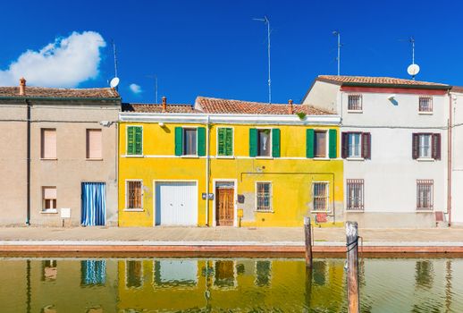 Colored houses reflected in the water. The old street in Comacchio - a small town in the province of Ferrara (Emilia Romagna), also known as "The Little Venice"