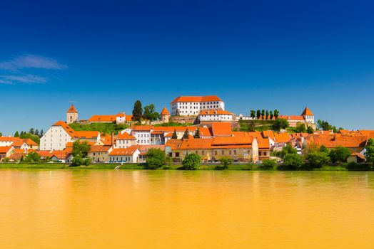 Cityscape of the old european town Ptuj, Slovenia. Panoramic view of the small cozy town. Traditional architecture with orange tile roof. Bank of the Drava River