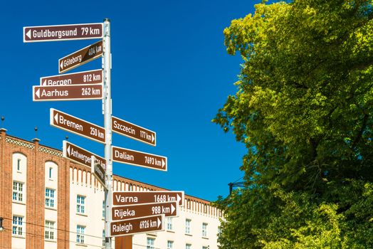 Street sign with directions pointers and distances to the different cities of the world. Rostock, Germany