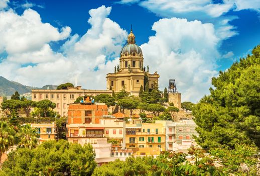 Cityscape of Messina with Cathedral on the top of the hill, colored houses and beautiful clouds with a blue sky, Sicily, Italy