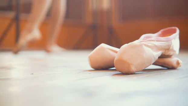 Close up of a ballet dancer's shoe in front of girl, wide angle