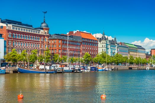 Beautiful cityscape of Helsinki with the traditional architecture, wharf with boats and clear blue sky on the background, Finland