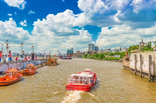 A red ship with tourist is sailing on the Elbe River in Hamburg, Germany
