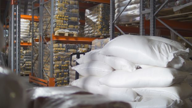A bags with sugar inside a large industrial warehouse, wide angle