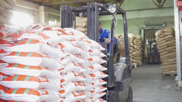 Red loaders transport pallet with boxes on industrial warehouse, wide angle